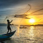 person-throwing-fish-net-while-standing-on-boat feature image for I don't want to work.jpg