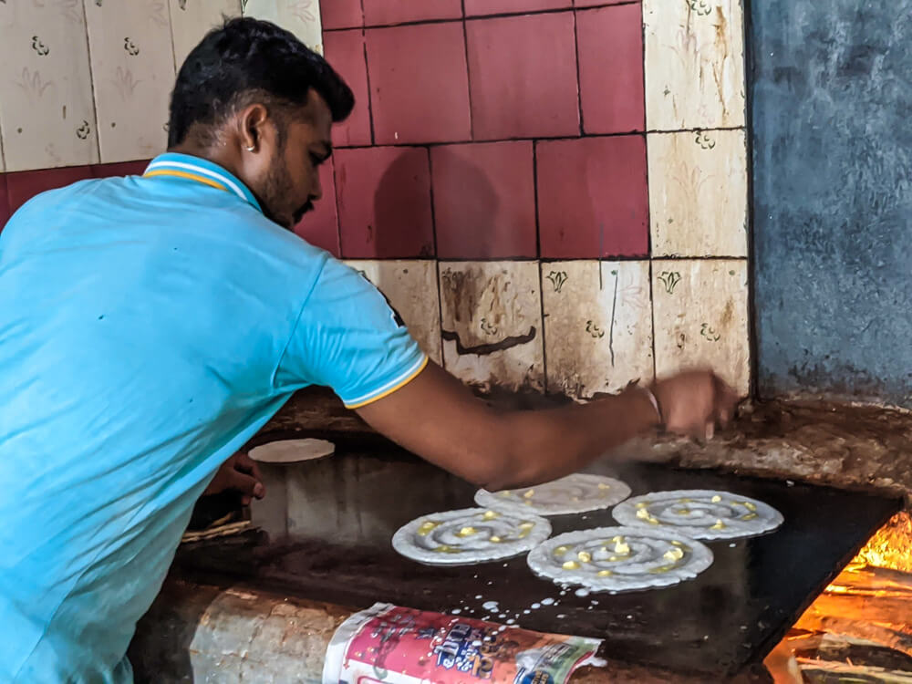 adding butter to davanagere benne dosa on woodfire