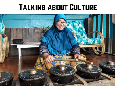 world culture article category shown through a Malaysian woman in traditional attire playing her native music instrument