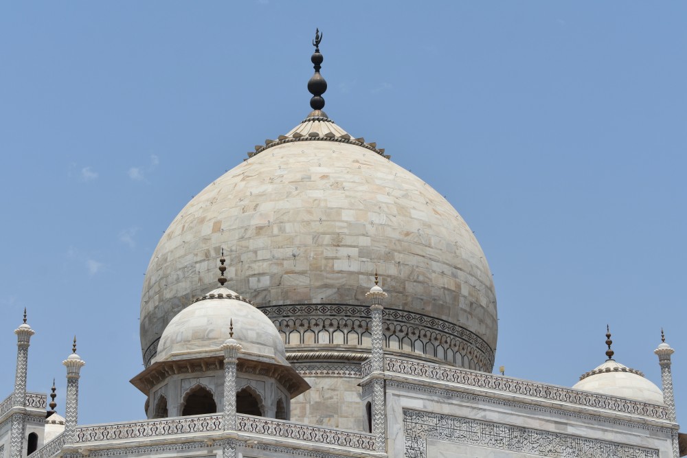a close up of the dome without any particular symmetry but you can see the quranic verses inscribed and the flower designs too