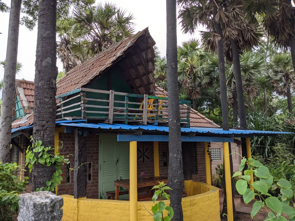 a little yellow hut in the auroville area of tamil nadu