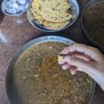 eating makka roti with maa ki dal in himachal a bite in author's hand