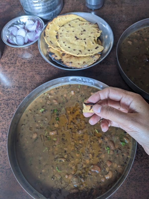 eating makka roti with maa ki dal in himachal a bite in author's hand