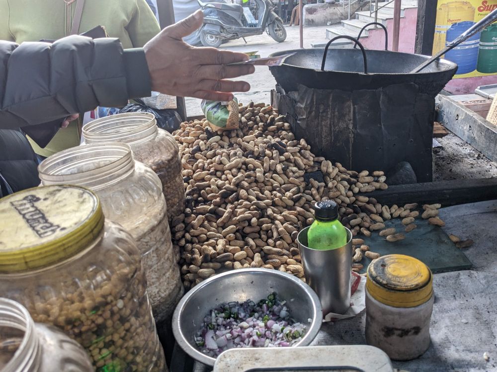 money being handed for roasted peanuts being sold