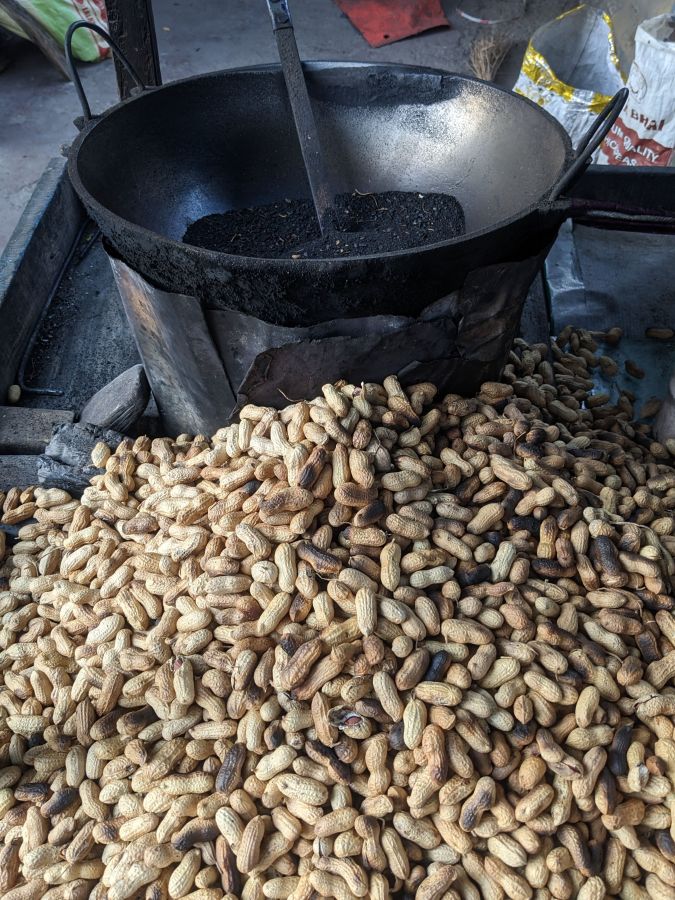 peanuts being roasted in sand on siliguri streets