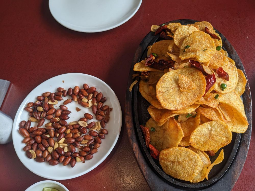 believe it or not peanut and crisps make for a good break, potato crisps and salted peanuts on a table