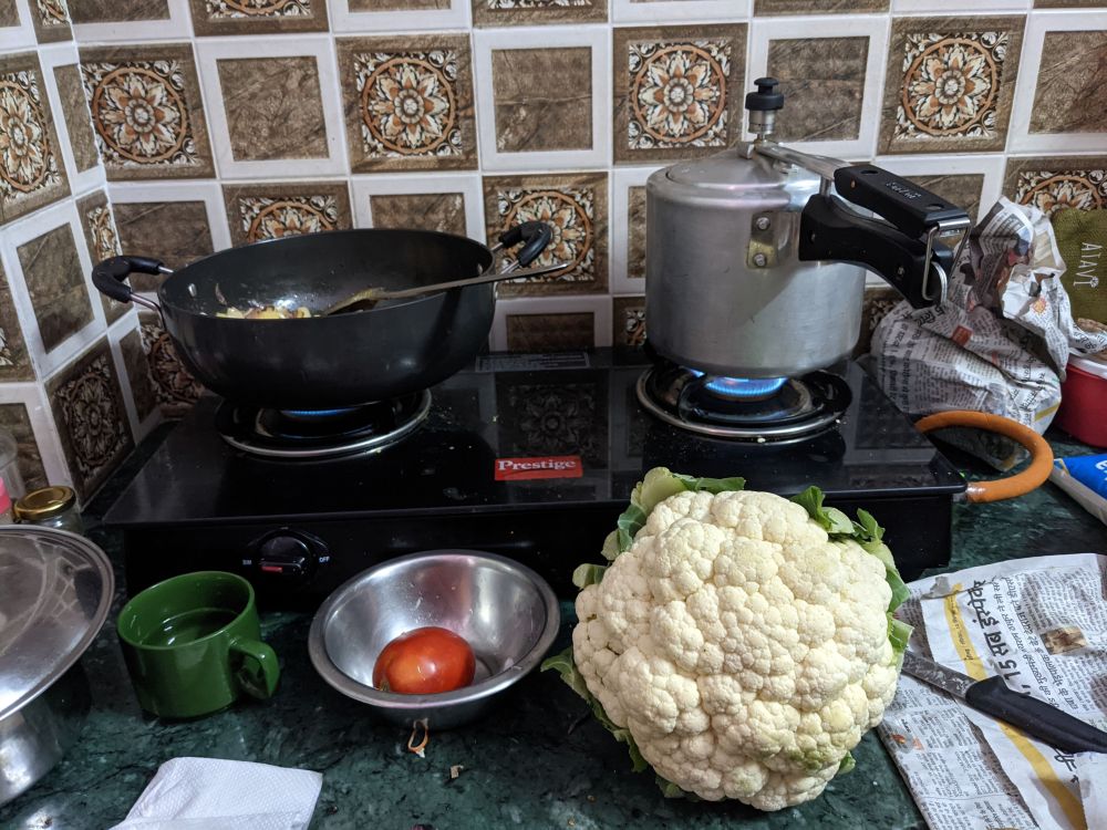 a fairly large cauliflower, stove, gas on under work and pressure cooker
