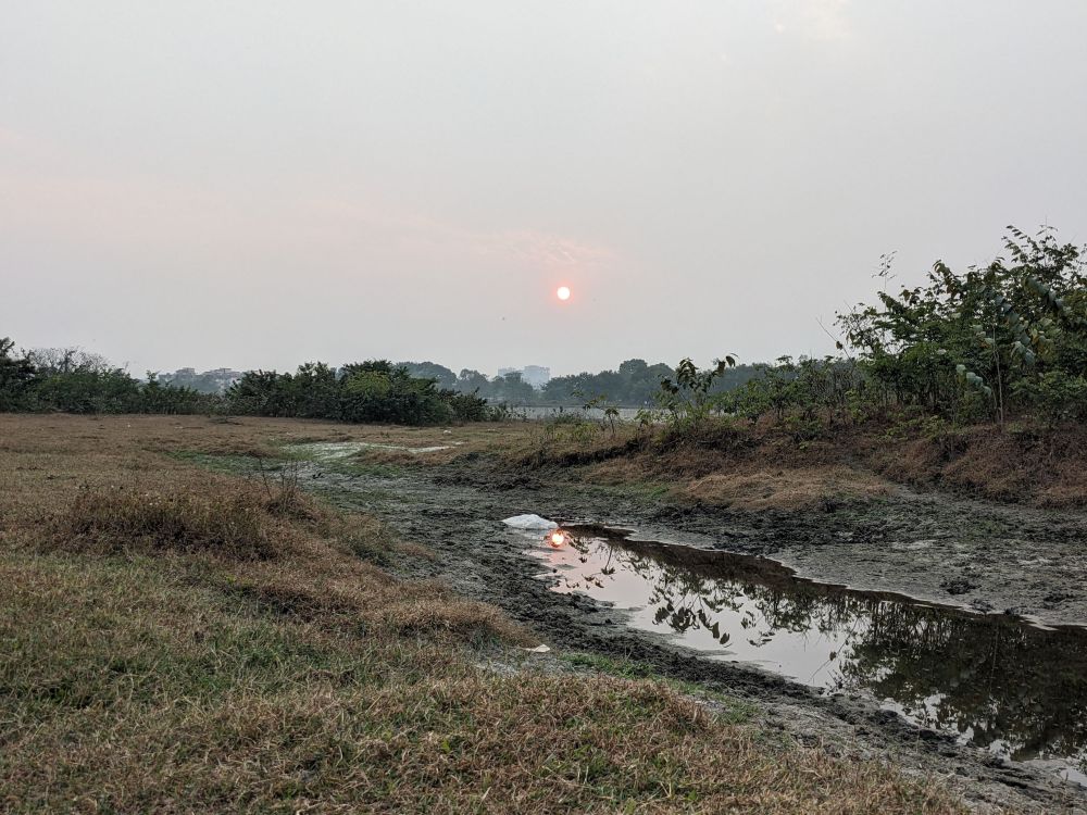 a sunset reflected in water on land