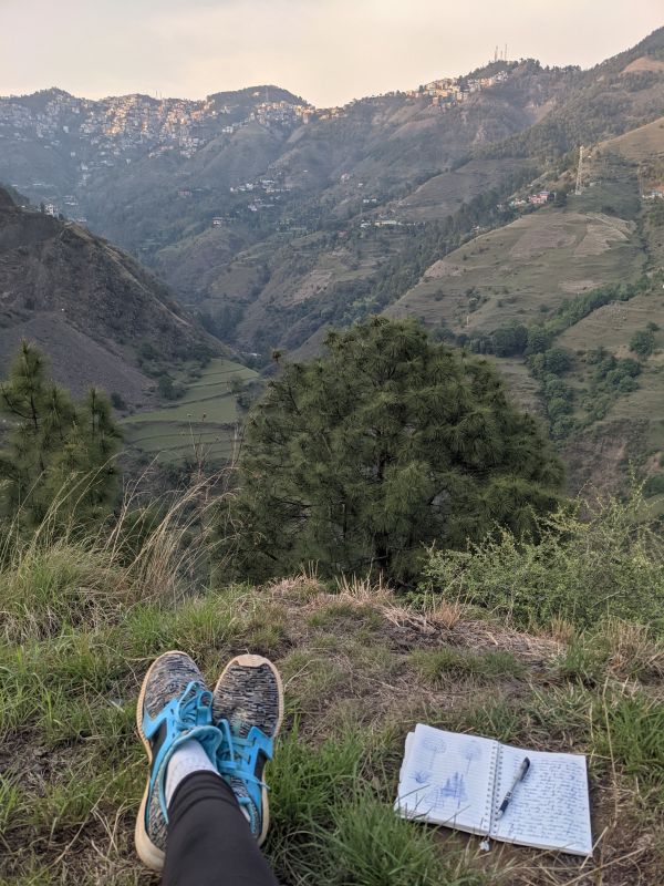 photo of the author feet alongside a diary with notes on the mountains