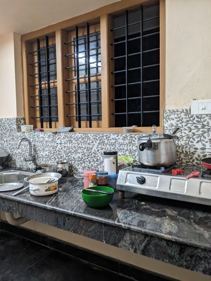 a kitchen with windows open to the dark in a village in kerala in wayanad district