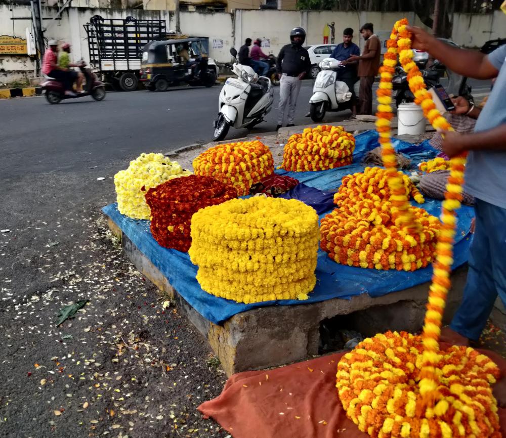 rolls of garlands mostly of mariegold flowers on the street corners as seen on mysore trip