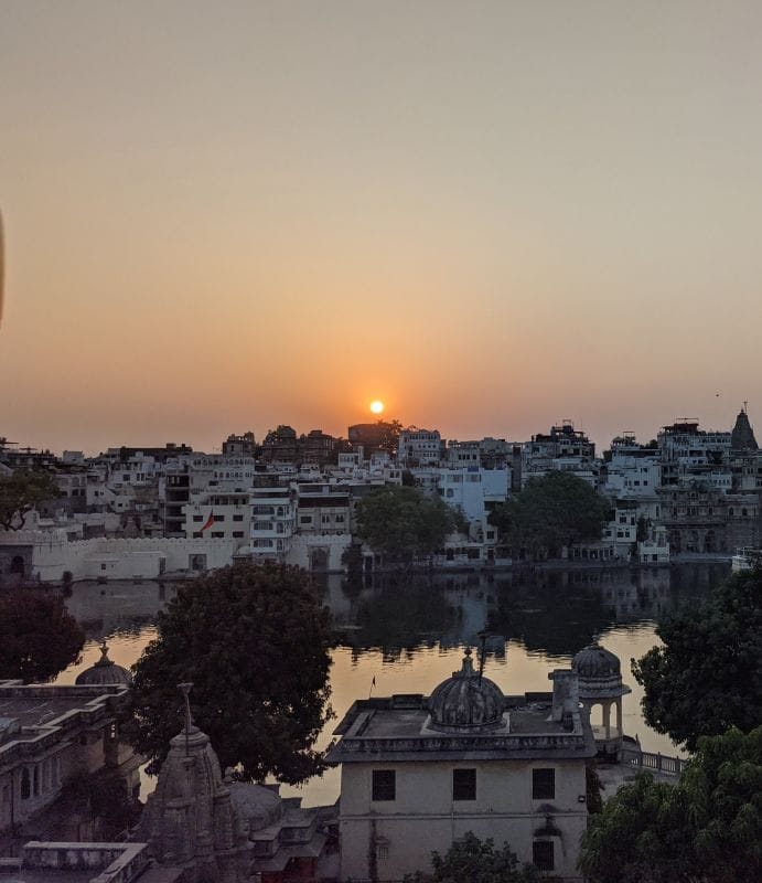 the sunset over the lake pichola udaipur rajasthan tiny
