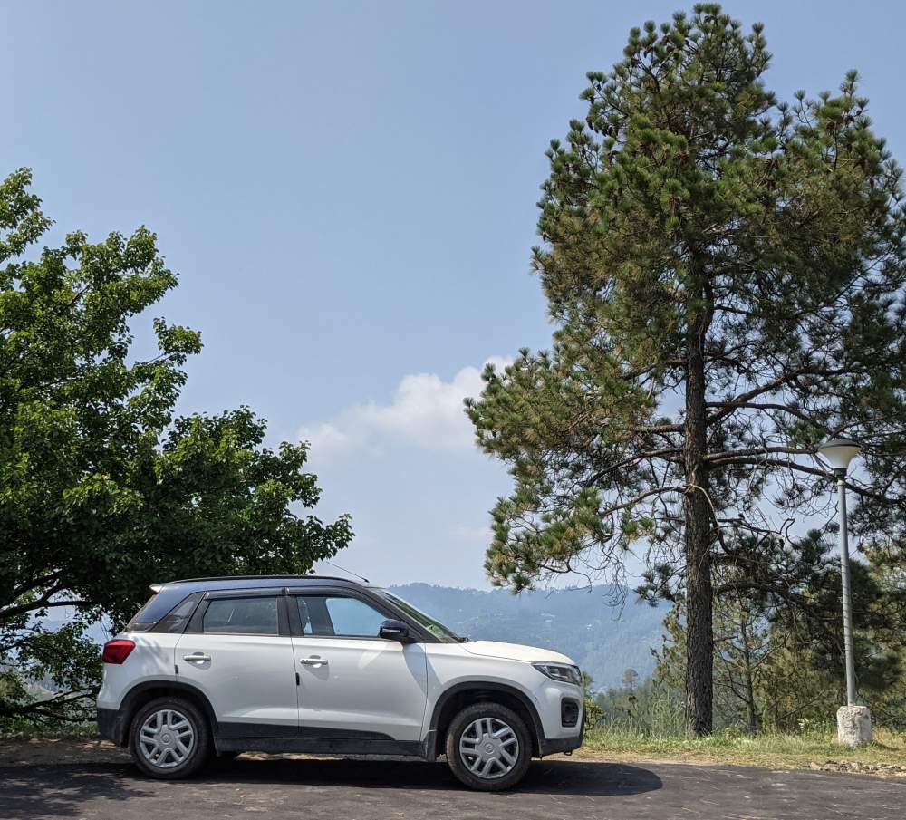 How We Bought a Car in Bangalore and Became Nomads 1 beautiful brezza car parked in himachal mountains india feature image for buy a used car versus new car in bangalore karnataka (1)
