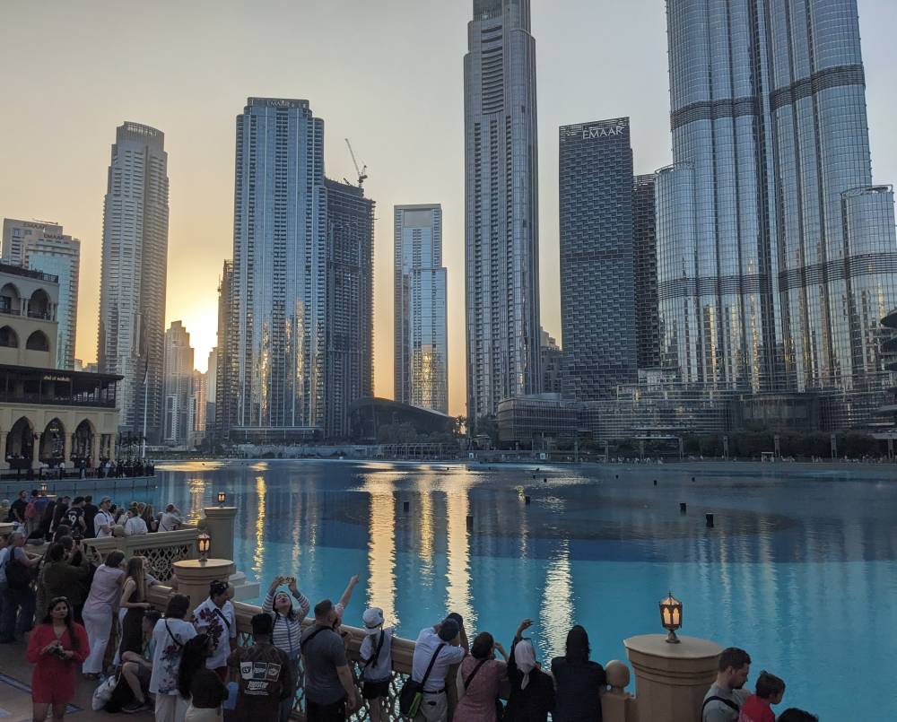 UAE Visa on Arrival For Indians (With Valid US, UK, Schengen Visa) 2 bright glass buildings blue water pool tourists Dubai UAE visa on arrival for indians article image