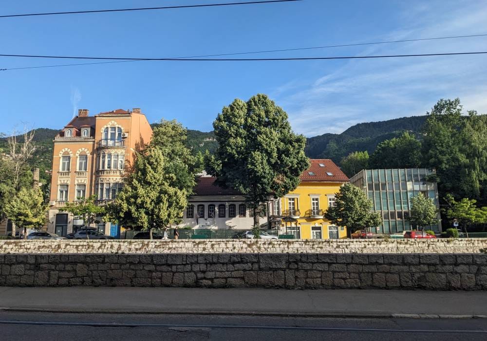 Sauntering Along Sarajevo, Bosnia and Herzegovina: An Unusual Travel Guide 2 the old buildings of sarajevo across the tram trees road city of sarajevo bosnia and herzegovina