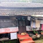homestays in mangalore a home with brick tiled roof a dog outside